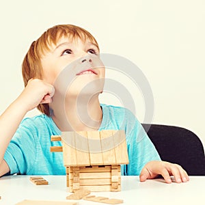 Little boy builds house from wooden blocks. My house concept. Concept of dream home and mortgage investment. Little boy playing as