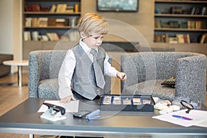 Little boy in business clothes playing with a