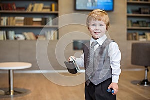 Little boy in business clothes with a puncher and photo