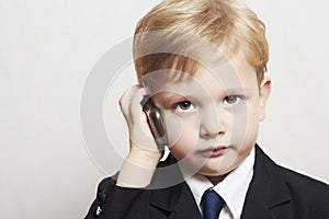 Little boy in business suit with cell phone. handsome child. fashionable kid