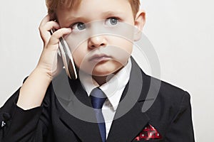 Little boy in business suit with cell phone. handsome child. fashionable kid