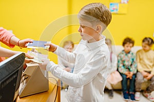 Little boy buying ticket in playroom