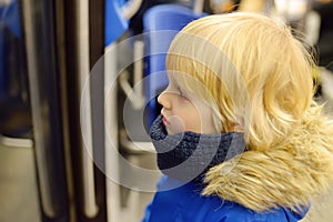 Little boy in a cabin of subway or tram car. Child passenger of comfortable transport of big city. Urban infrastructure