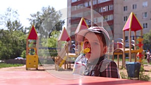 Little boy in cap drinking water