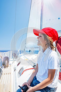 Little boy captain on board of sailing yacht on summer cruise. Travel adventure, yachting with child on family vacation.