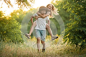 Little boy carries girl on his back.