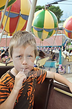 Little boy on a carrousel in amusement park