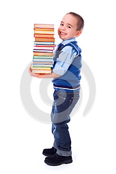 Little boy carrying stacked books