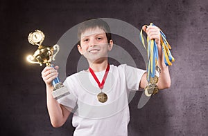 Little boy celebrates his golden trophy