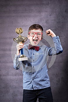 Little boy celebrates his golden trophy