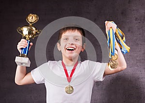 Little boy celebrates his golden trophy