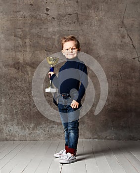 Little boy celebrates his golden trophy
