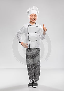 little boy in chef& x27;s toque showing thumbs up