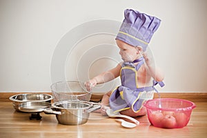 Little boy in a chief hat and aprons cooking