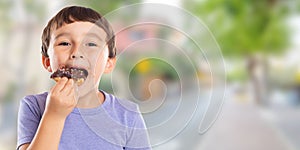 Little boy child eating donut town banner copyspace unhealthy sweet sweets