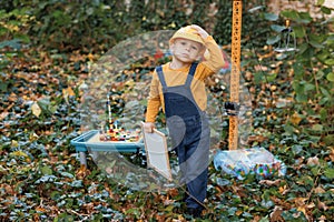 Little boy child future engineer builder architect with safety helmet looking on new buildings and construction cranes