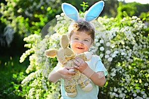 Little boy child in green forest. Happy easter. Childhood. Egg hunt on spring holiday. Rabbit kid with bunny ears. Hare