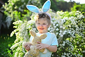 Little boy child in green forest. Happy easter. Childhood. Egg hunt on spring holiday. Rabbit kid with bunny ears. Hare