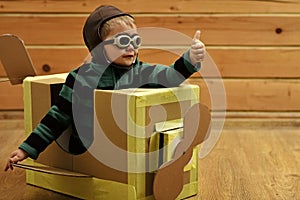Little boy child play in cardboard plane, childhood.