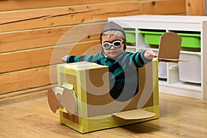 Little boy child play in cardboard plane, childhood.