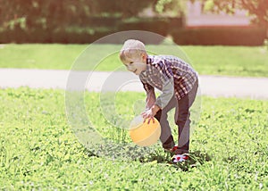 Little boy child playing with ball outdoors on the grass