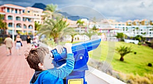 Little boy child playing with public pay telescope