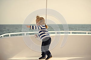 Little boy child playing in white yacht. Childhood and baby care concept.