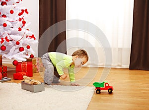 Little boy in Christmas, playing with new toy car