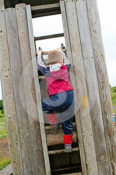 Little boy climbing a ladder