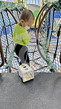 Little Boy Climbing The Net At Indoor Playground