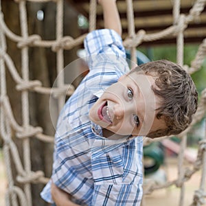 Little boy climbing a rock wall outdoor