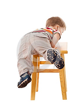 Little boy climbing on stool