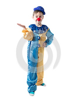 Little boy in clown suit with a cap and a red nose is showing something with hand