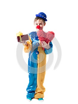 Little boy in clown suit holding a box with a bow in one hand and a big red heart in the other hand