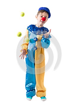 Little boy in clown suit juggling three balls and smiling