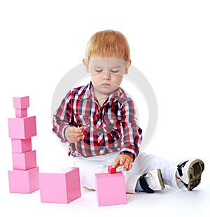 Little boy collects pink pyramid.