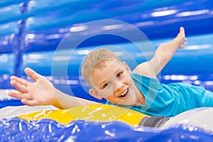 Little boy on colorful playground trampoline. Kids jump in inflatable bounce castle on kindergarten birthday party. Activity and p