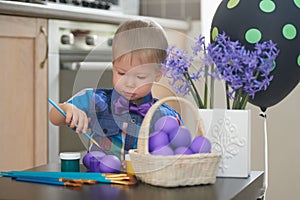 Little boy coloring easter eggs