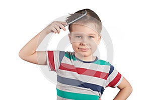 Little boy combing his hair, isolated on white background