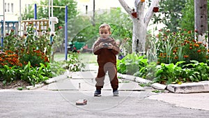 Little boy controls a small toy car using a remote control