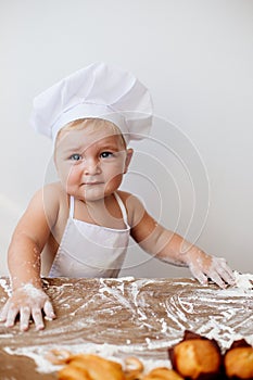 Little boy in a cook suit with buns