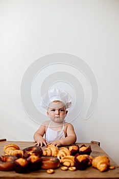 Little boy in a cook suit with buns