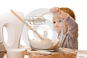 Little boy cooking and making mess in kitchen