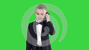 Little boy in a costume making a phone call while walking on a Green Screen, Chroma Key.