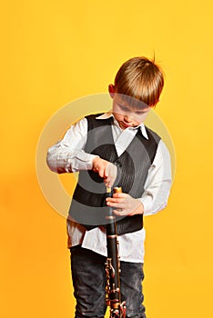 A little boy in costume tunes the clarinet before playing the music scene