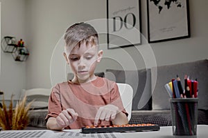 Little boy Counting with help an abacus. Mental arithmetic, brain development