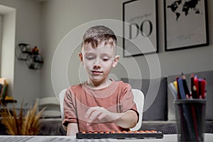 Little boy Counting with help an abacus. Mental arithmetic, brain development