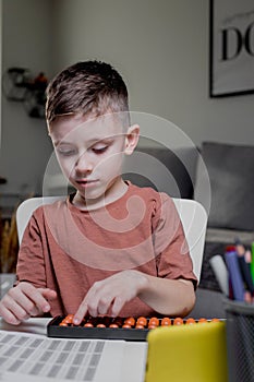 Little boy Counting with help an abacus. Mental arithmetic, brain development