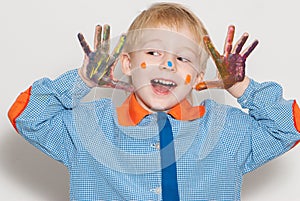 Little boy covered in paint making funny face