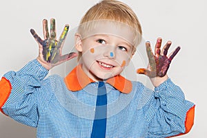 Little boy covered in paint making funny face